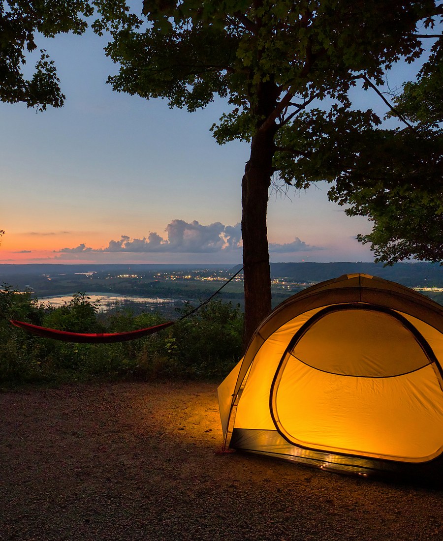 Warm glowing tent in a forest campsite