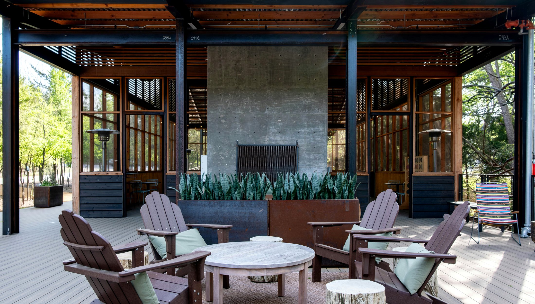 Refined outdoor patio with fireplace and Adirondack seating in Texas